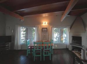 a dining room with a table and green chairs at Isla Casinha Delta Tigre in Tigre