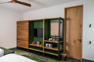 a bedroom with a green and wooden cabinet with a television at Cinco Rodavento in Valle de Bravo