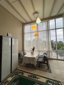 a living room with a table and a large window at Gyuzel villa di lembang in Citeureup 1