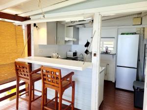 a kitchen with two chairs and a counter and a refrigerator at Ti Kaz Robin in Trois-Rivières