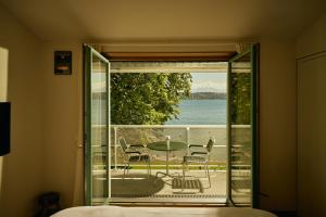 a room with a balcony with a table and chairs at Auberge Port Gitana in Bellevue