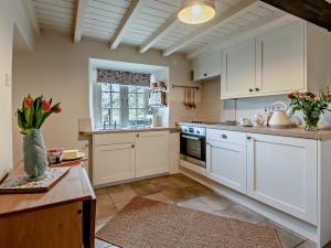 a large kitchen with white cabinets and a window at 2 Bed in Buxton oc-95993 in Hartington