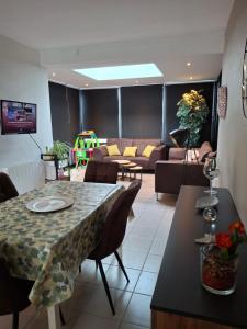 a living room with a table and a couch at Maison de vacances Etoile de mer 2 in Koksijde +6 photos