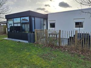 a white house with a fence in front of it at Maison de vacances Etoile de mer 2 in Koksijde