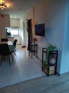 a living room with a table and a tv on a wall at Maison de vacances Etoile de mer 2 in Koksijde