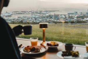 a table with plates of food and a view of the ocean at Hotel Føroyar in Tórshavn +69 photos