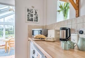 a kitchen with a counter top with a coffee maker at South Cottage in Sherborne +29 photos