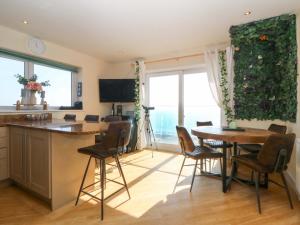 a kitchen and dining room with a table and chairs at Snowdonia View in Pwllheli