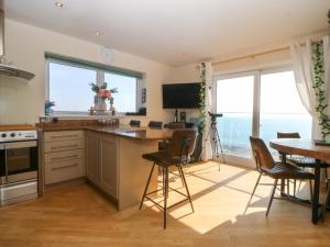 a kitchen with a table and chairs and some windows at Snowdonia View in Pwllheli