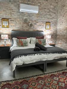 a bedroom with a large bed in a brick wall at Apple Cottage in Grabouw