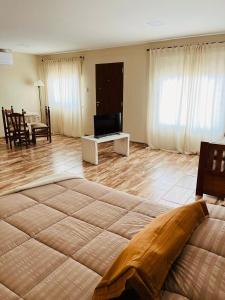 a large bedroom with a large bed and a living room at Corazón de Ayrampos APART in Villa Dolores