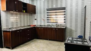 a kitchen with wooden cabinets and a stove in it at Prime Ville in Rubuchi