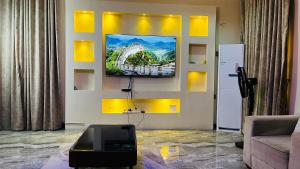 a living room with a television on a wall at Prime Ville in Rubuchi