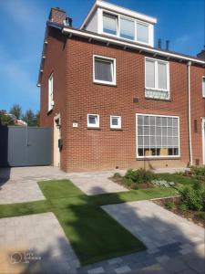 a brick house with a lawn in front of it at Saskia's logeerhuis in Arnhem