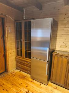 a stainless steel refrigerator in a kitchen with wooden floors at Zofiówka las in Zofiówka