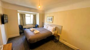 a hotel room with a bed with two teddy bears on it at Russel Court Hotel Bournemouth Central in Bournemouth