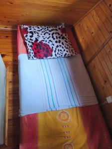 a bed with a colorful comforter and a pillow at Zofiówka las in Zofiówka