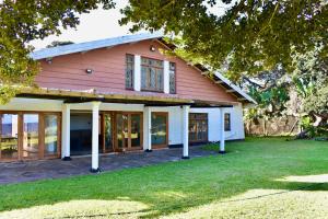 a red and white house with a yard at Berna Coastal Retreat in Port Shepstone