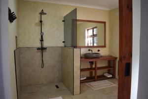 a bathroom with a shower with a sink and a mirror at Berna Coastal Retreat in Port Shepstone +8 photos