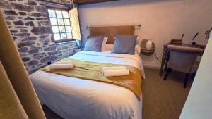 a bedroom with a bed with two pillows on it at Le Puits Enchanté in Espalion