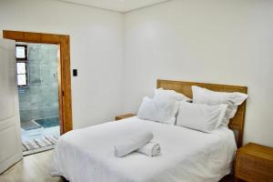 a bedroom with a large white bed with white pillows at Berna Coastal Retreat in Port Shepstone