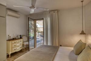 a bedroom with a bed and a dresser and a window at Les Hamaques hotel in Viladamat