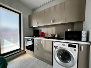 a kitchen with a washing machine and a microwave at Virello Aparthotel 4 SELF CHECK-IN #Otopeni #Airport #Therme #Bucharest in Otopeni