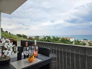 a table with wine glasses on top of a balcony at Appartamento Rosa Calabria in Roseto Capo Spulico