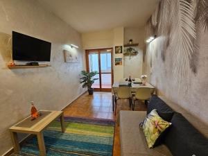 a living room with a couch and a table at Appartamento Rosa Calabria in Roseto Capo Spulico