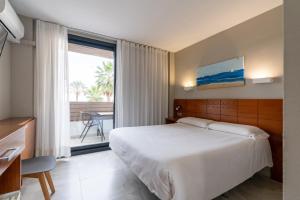 a hotel room with a bed and a large window at Hotel Costa Azahar in Grao de Castellón