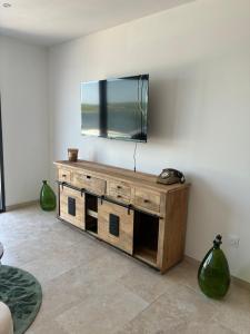 a living room with a tv on a wall at Les clés de Jules in Gruissan