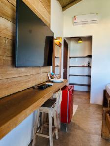 a room with a counter and a red suitcase at Tamikuã Mar Pousada in Caraíva