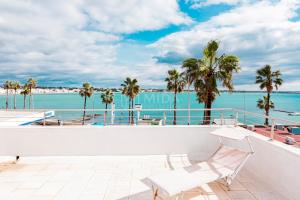 a white chair sitting on a balcony overlooking the ocean at DIO DEL MARE LUXURY ROOM in Porto Cesareo