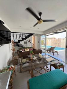 a living room with a table and a ceiling fan at Casa de Descanso Lili in Ricaurte