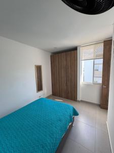 a bedroom with a blue bed and a window at Casa de Descanso Lili in Ricaurte