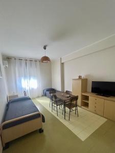 a bedroom with a bed and a table and a television at La pineta Apartment Tropea in Tropea