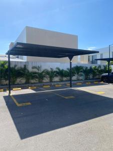 a parking lot with a blue canopy in front of a building at Casa de Descanso Lili in Ricaurte +3 photos