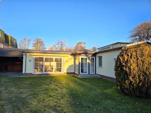 a house with a large yard in front of it at Häuschen im Grünen in Bansin