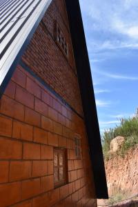 a brick building with two windows on the side at Be Happy Park Piracaia in Piracaia
