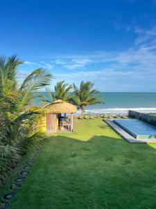 a backyard with a gazebo next to the beach at Tamikuã Mar Pousada in Caraíva
