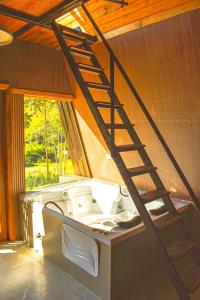 a bathroom with a bath tub with a ladder at Be Happy Park Piracaia in Piracaia