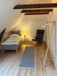 a attic bedroom with a bed and a chair at Slotsgaarden ved Hesten in Randers