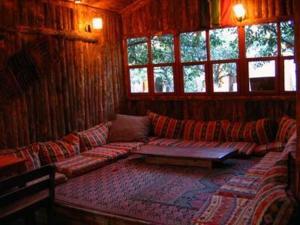 a living room with a couch in a room with windows at Bayrams Tree Houses in Olympos