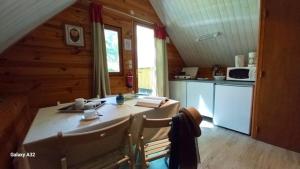a kitchen with a table and chairs in a cabin at TRAPPEUR - Les Chalets du lac Belcaire in Belcaire