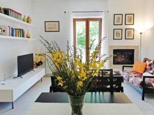 a living room with a vase with yellow flowers on a table at Casa Tonino in Pisticci