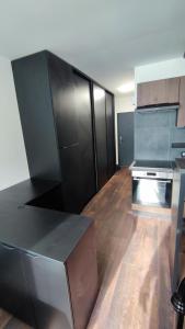 a large kitchen with black cabinets in a room at Centrum apartman s parkovaním in Trenčín +2 photos