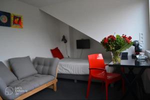 a living room with a couch and a table and a bed at Saskia's logeerhuis in Arnhem