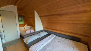 a small bedroom with a bed in a room with wooden walls at Glamping at Honnington Farm in Royal Tunbridge Wells