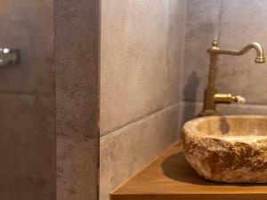 a bathroom with a stone sink with a faucet at Nido sull`Aqua Chalet with Whirlpool in Sigriswil