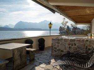 a patio with a table and benches and a view of the water at Nido sull`Aqua Chalet with Whirlpool in Sigriswil